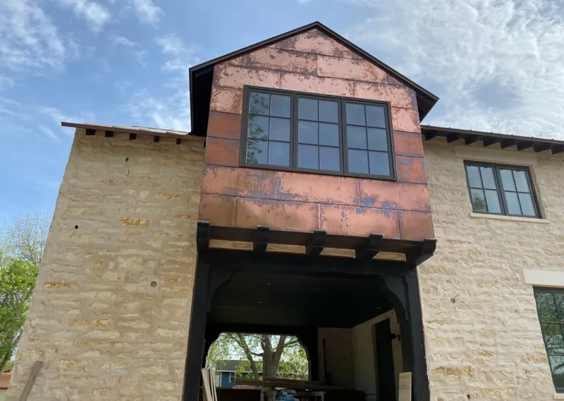 Copper metal panel facade on a stone building for Skylight Installation in Gunnison